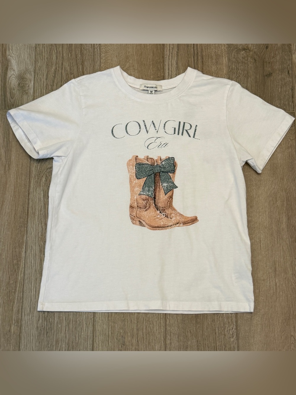 Francesca's Cowgirl Era White Tee with Tan Boot and Green Bow Graphic Shirt